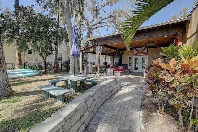 exterior space with a patio, french doors, and fence