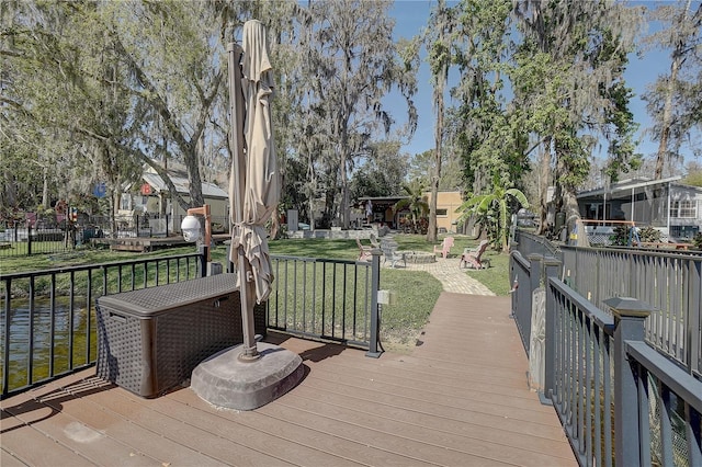 wooden deck featuring an outdoor fire pit and a yard