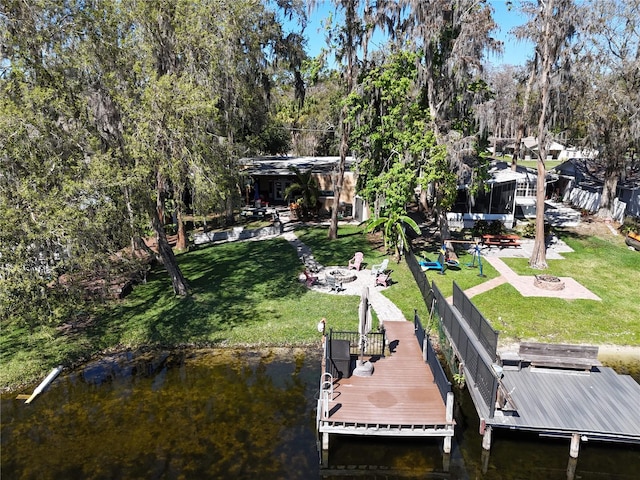 dock area with a patio, an outdoor fire pit, a lawn, and a water view