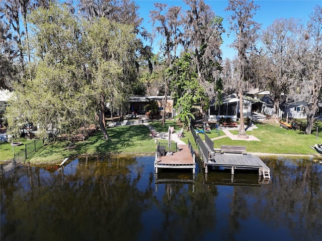 view of dock featuring a water view, fence, and a yard
