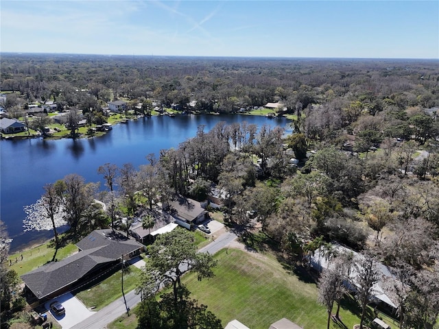 birds eye view of property featuring a water view and a wooded view
