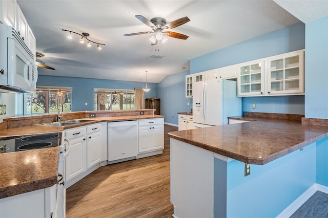 kitchen with white appliances, glass insert cabinets, decorative light fixtures, a peninsula, and white cabinetry