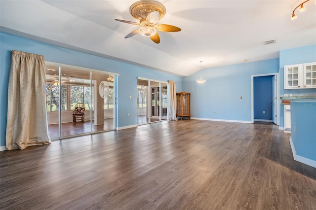 unfurnished living room with ceiling fan, lofted ceiling, visible vents, baseboards, and dark wood-style floors