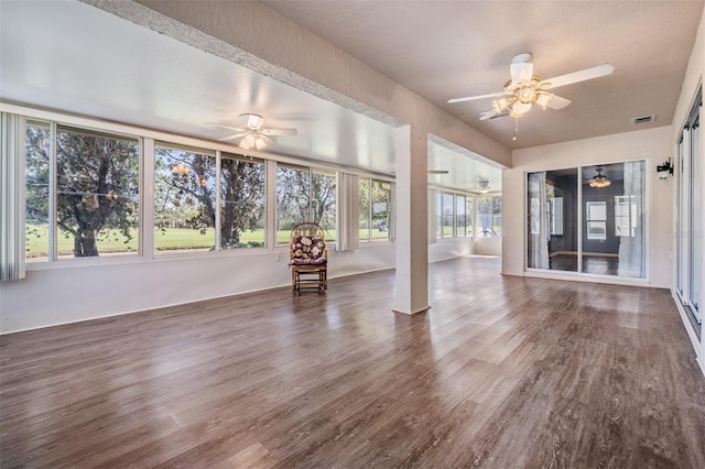 unfurnished sunroom featuring visible vents and a ceiling fan