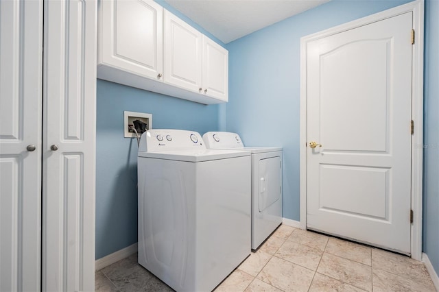 laundry area featuring baseboards, cabinet space, washing machine and clothes dryer, and light tile patterned floors