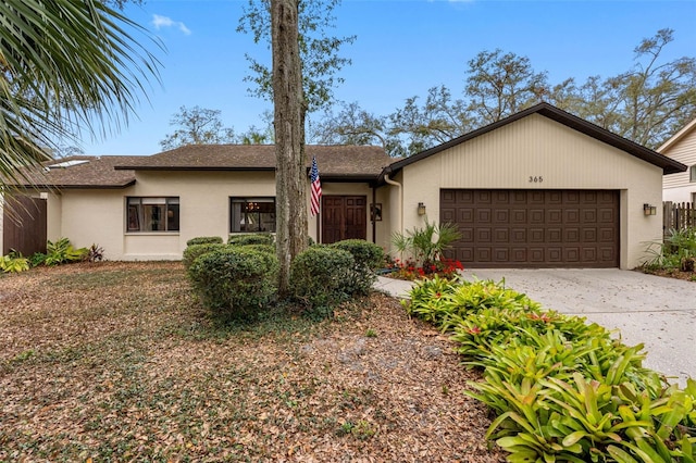 view of front of house with an attached garage, concrete driveway, and stucco siding