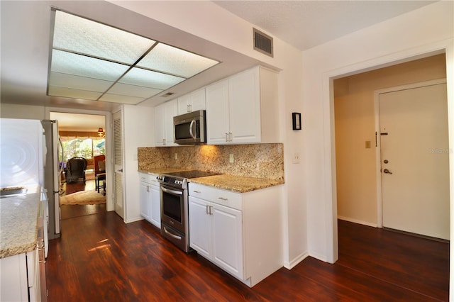 2630 Pearce Dr Unit 107, Clearwater, FL 33764 - kitchen featuring backsplash, dark wood-style flooring, appliances with stainless steel finishes, and white cabinets