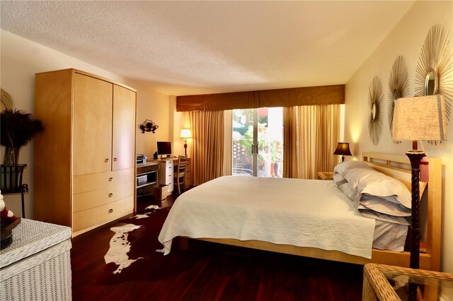2630 Pearce Dr Unit 107, Clearwater, FL 33764 - bedroom featuring access to outside, dark wood-type flooring, and a textured ceiling