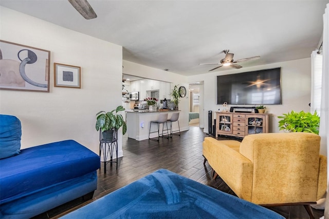 living area with dark wood-style flooring and a ceiling fan