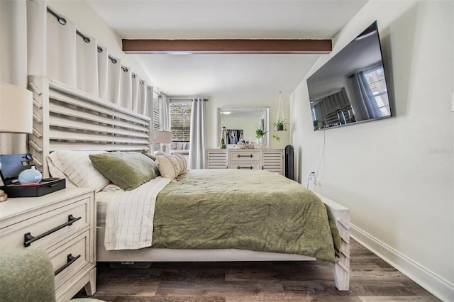 bedroom with beamed ceiling, dark wood finished floors, and baseboards