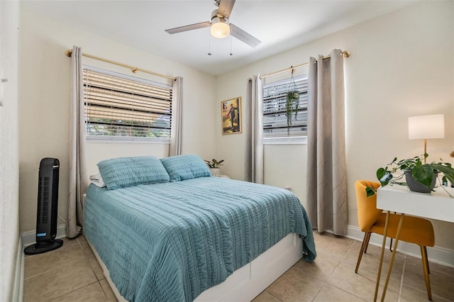 bedroom featuring ceiling fan, light tile patterned floors, and baseboards