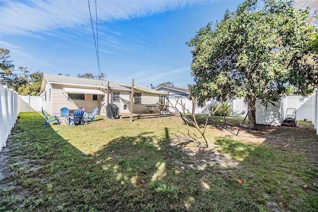 rear view of property with a fenced backyard and a lawn