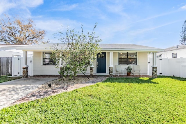 ranch-style house featuring covered porch, fence, a front lawn, and concrete driveway