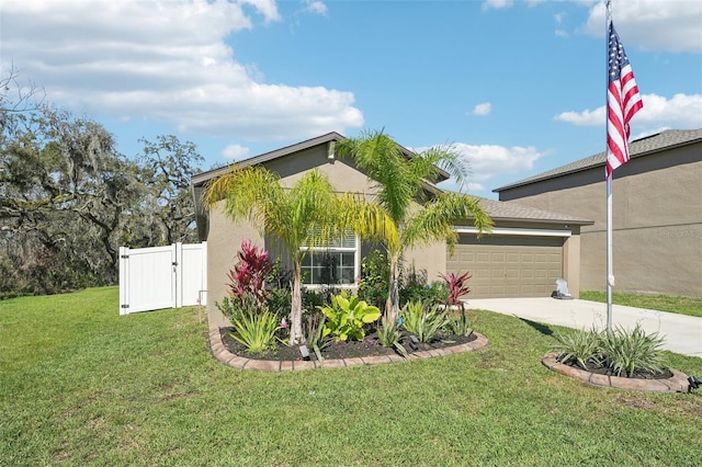 view of front facade with an attached garage, concrete driveway, a gate, stucco siding, and a front yard