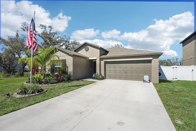 ranch-style home featuring a garage, driveway, fence, a front lawn, and stucco siding