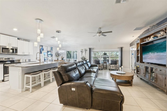 living area with light tile patterned flooring, ceiling fan, and visible vents