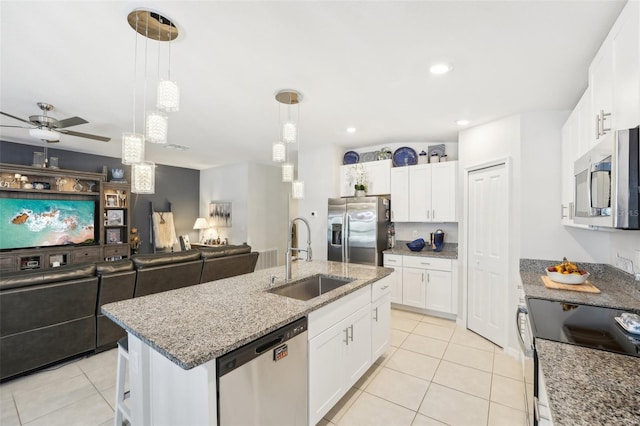 kitchen featuring stainless steel appliances, white cabinetry, a sink, and an island with sink