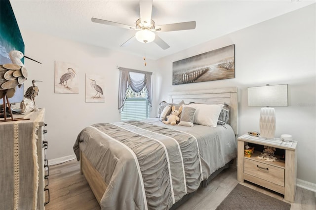 bedroom featuring ceiling fan, light wood-type flooring, and baseboards