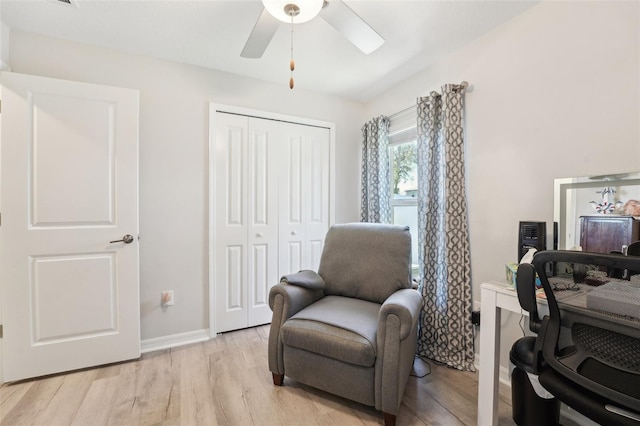 office area with a ceiling fan, light wood-type flooring, and baseboards