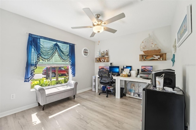 office space featuring a ceiling fan, baseboards, and wood finished floors