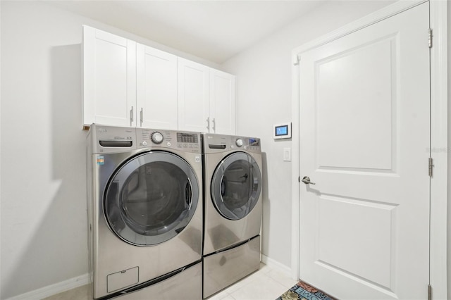 washroom featuring cabinet space, light tile patterned floors, baseboards, and independent washer and dryer