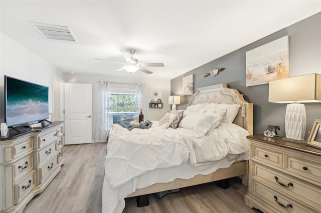 bedroom with ceiling fan, light wood-style flooring, and visible vents