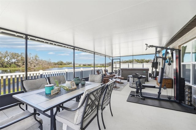 sunroom / solarium featuring a water view