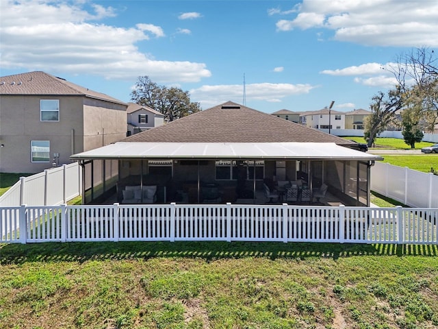 rear view of property with a lawn, a fenced backyard, and a sunroom