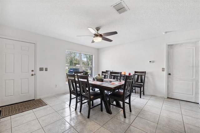 dining space with a ceiling fan, visible vents, a textured ceiling, and light tile patterned floors