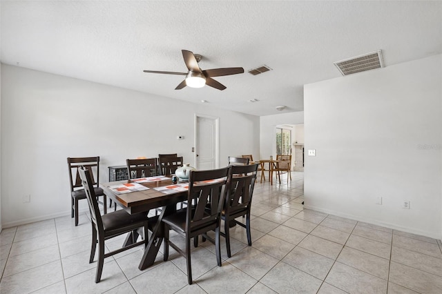 dining room featuring light tile patterned floors, a textured ceiling, and visible vents