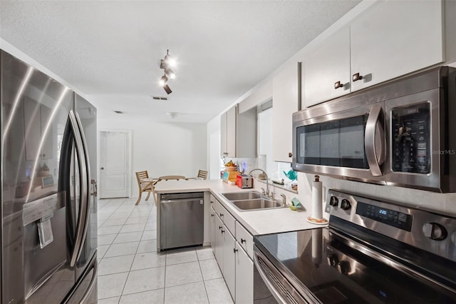 kitchen with light tile patterned floors, visible vents, stainless steel appliances, light countertops, and a sink