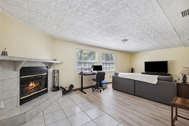 office area with a fireplace, wood finished floors, visible vents, and baseboards