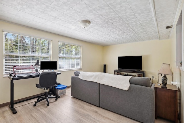 office area with baseboards, visible vents, and wood finished floors