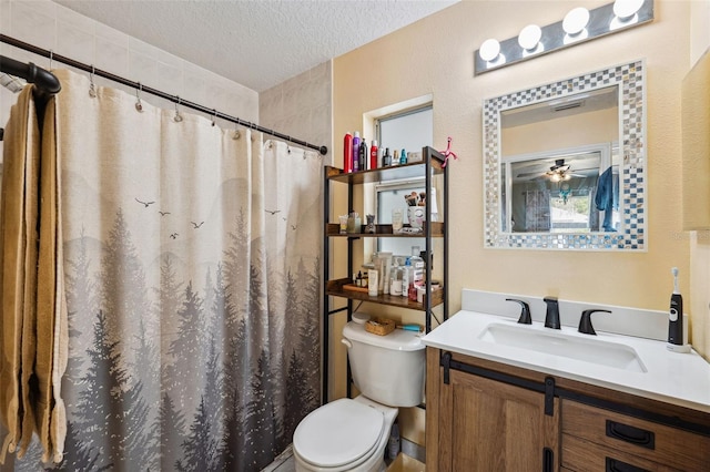 bathroom featuring a textured ceiling, ceiling fan, toilet, a shower with shower curtain, and vanity