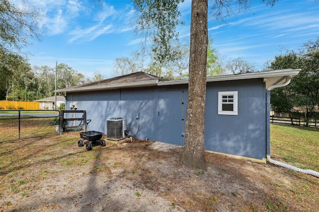 view of side of property with fence, cooling unit, and stucco siding