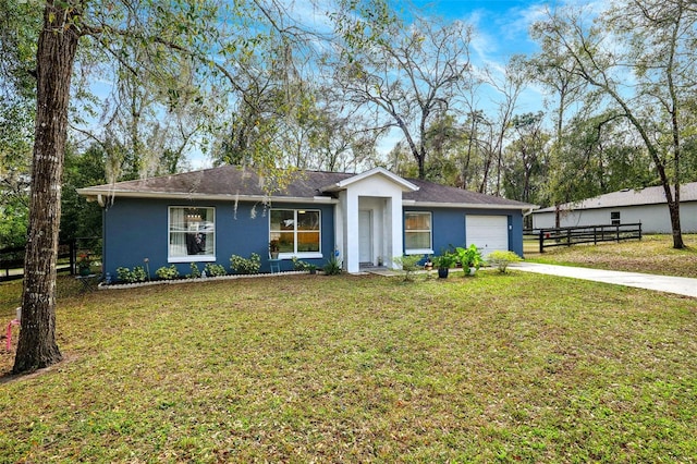 ranch-style home with a front lawn, driveway, an attached garage, and stucco siding