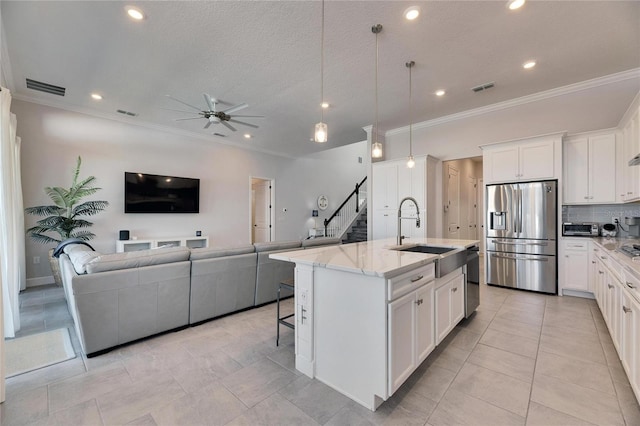 kitchen featuring open floor plan, stainless steel appliances, a sink, and visible vents