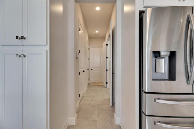 hall featuring recessed lighting, baseboards, and light tile patterned flooring