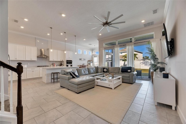 living area featuring a textured ceiling, visible vents, and crown molding