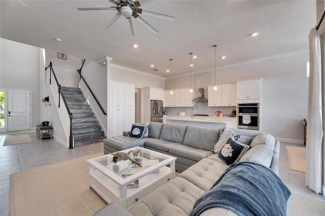 living room featuring light tile patterned floors, stairway, ornamental molding, a textured ceiling, and baseboards