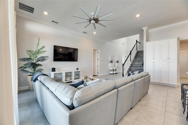 living area featuring stairs, ornamental molding, and visible vents