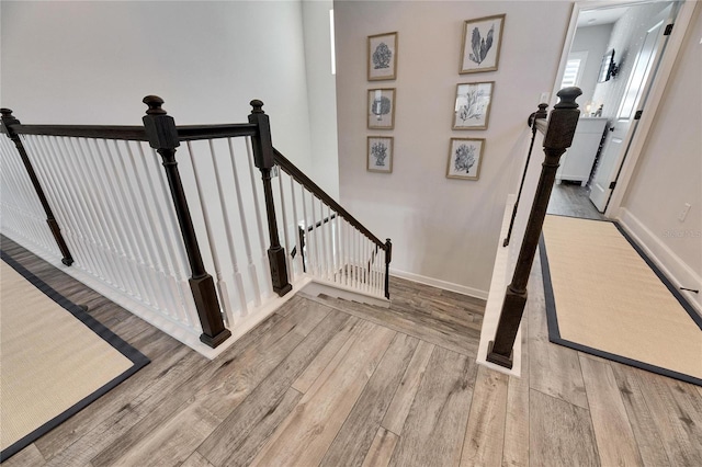 stairway with wood finished floors and baseboards