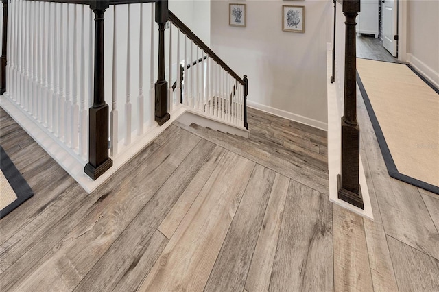 staircase with baseboards and wood finished floors