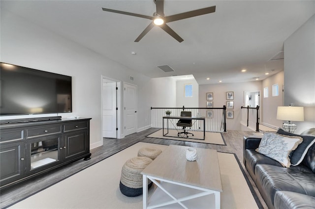 living room with baseboards, wood finished floors, visible vents, and recessed lighting