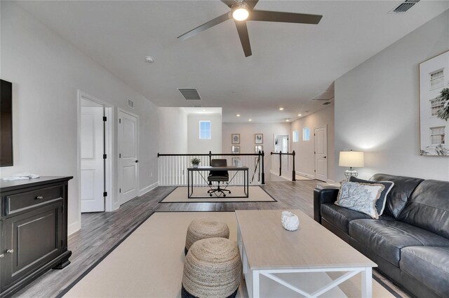 living area with baseboards, visible vents, wood finished floors, and recessed lighting