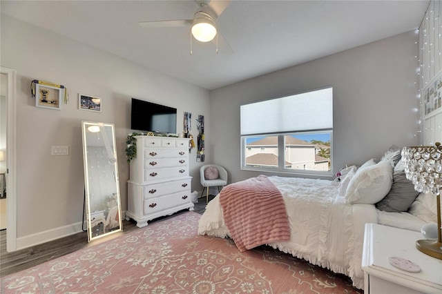 bedroom with wood finished floors, a ceiling fan, and baseboards