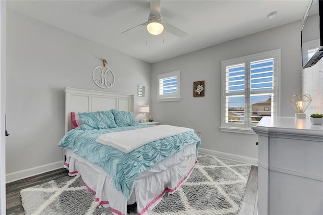 bedroom featuring ceiling fan, baseboards, and wood finished floors