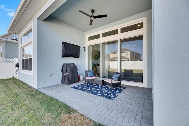 view of patio / terrace with fence and a ceiling fan