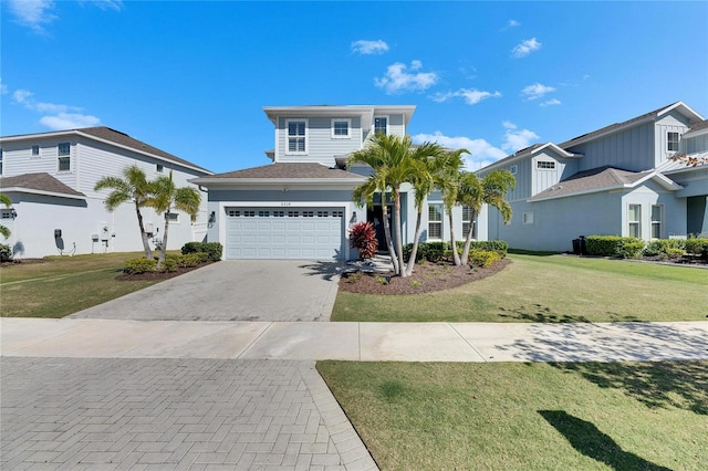 view of front of home featuring an attached garage, a front lawn, and decorative driveway