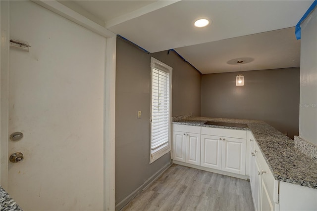 kitchen with baseboards, hanging light fixtures, white cabinetry, and light wood-style floors